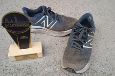 Zdjęcie ubłoconych butów po biegu ultra i wywalczonego trofeum 